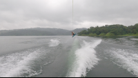 a man wakeboards jumping in the air above lake arenal on a foggy morning
 - Costa Rica