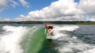 a woman wakesurfing on a sunny day on lake arenal
 - Costa Rica