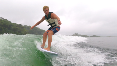 a man wakesurfs on lake arenal in the morning
 - Costa Rica