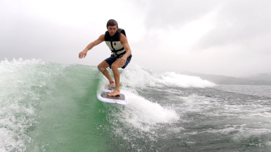 a man wakesufing on lake arenal in a rainy morning
 - Costa Rica