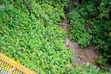 A Lady At The Bottom Of The Canyon In The Tarzan Swing Los Canones Canopy Tour La Fortuna
 - Costa Rica