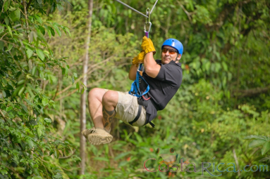 Man Zooming Across A Rainforest Field On Blue River Zipline
 - Costa Rica